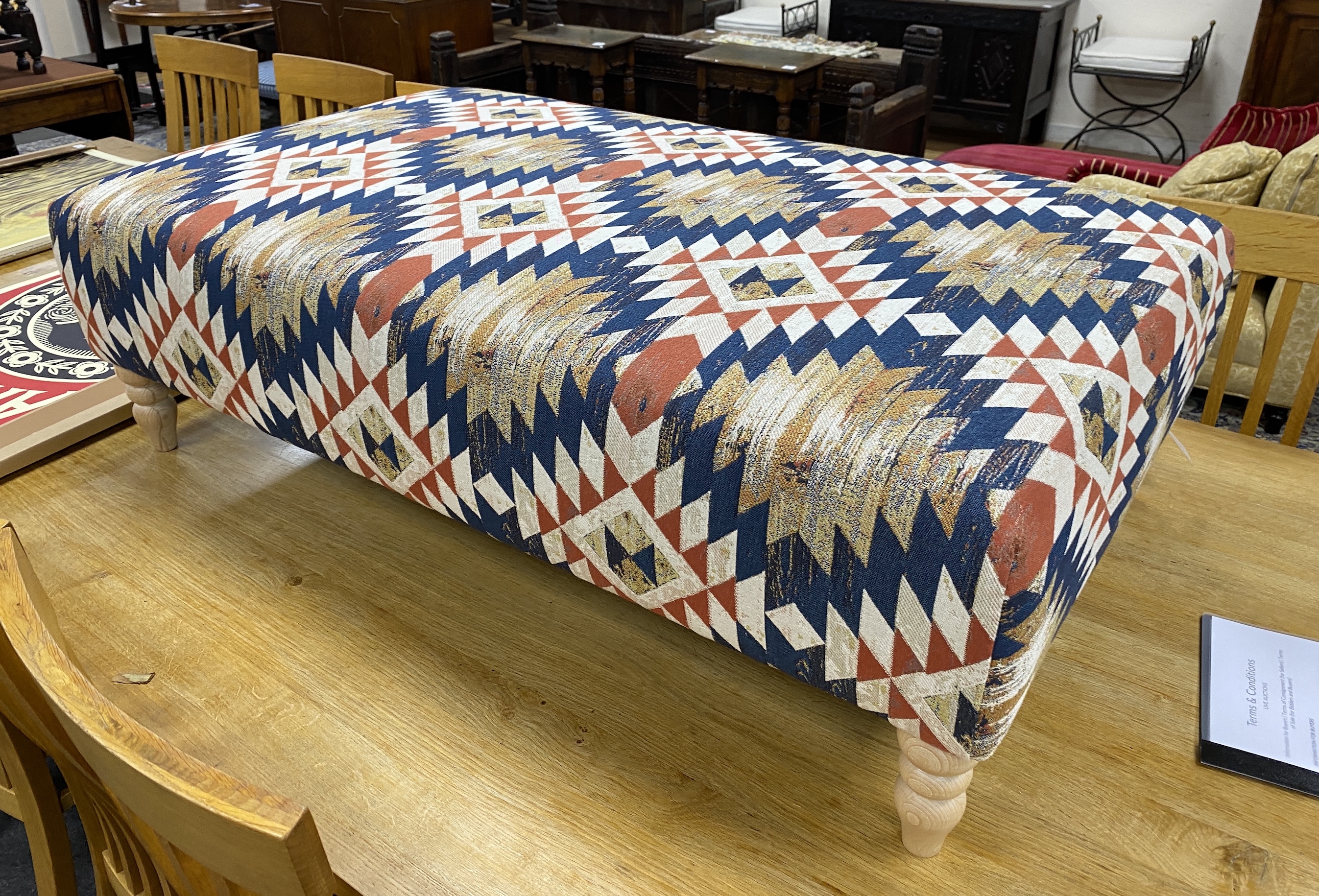 A large contemporary rectangular footstool upholstered in Kilim style polychrome fabric on turned beech feet, length 124cm, depth 75cm, height 38cm